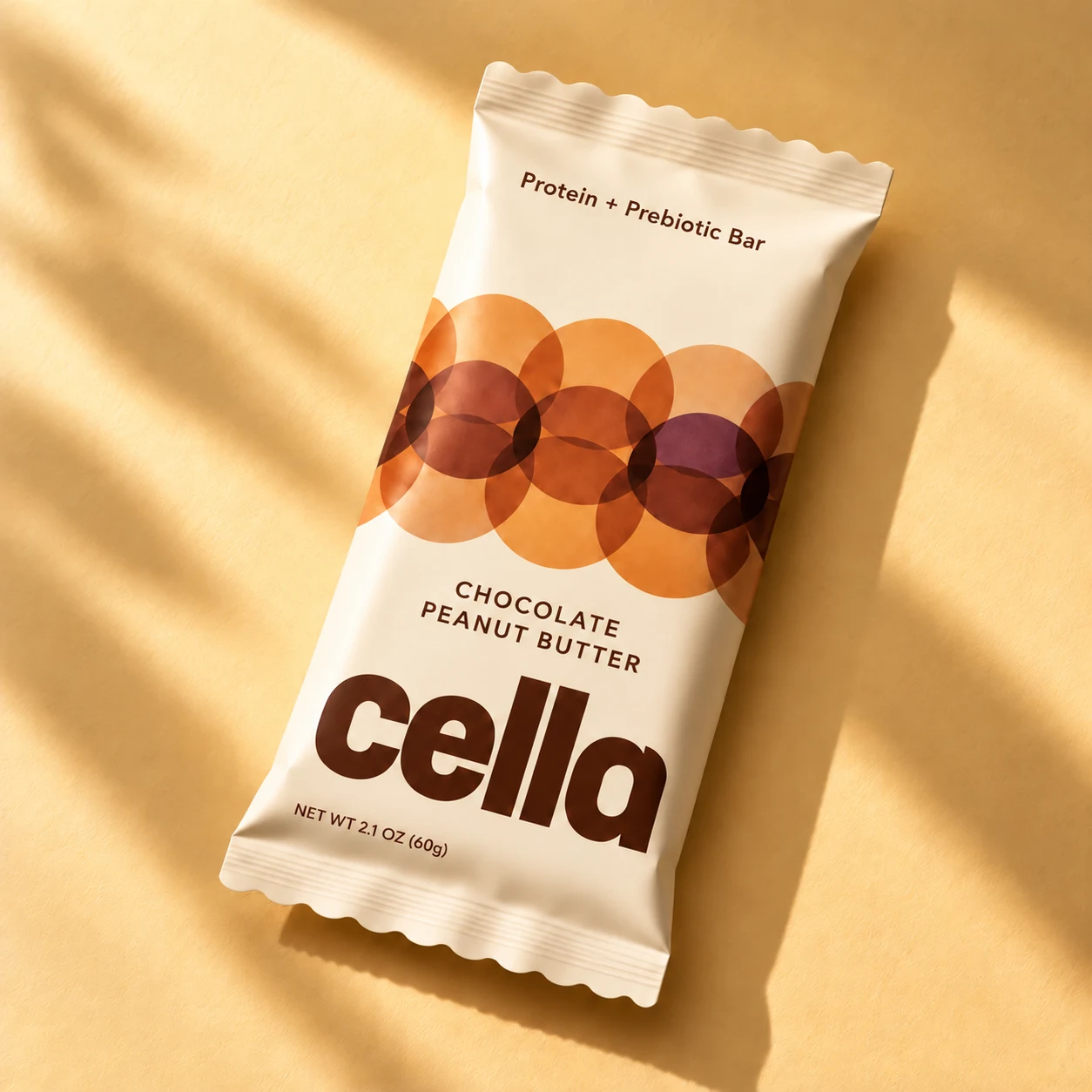 cella Chocolate Peanut Butter bar with warm overlapping circles on a buttery cream wrapper.